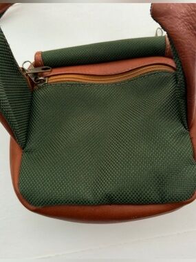 Leather belt bag with multiple compartments saddle brown and green.